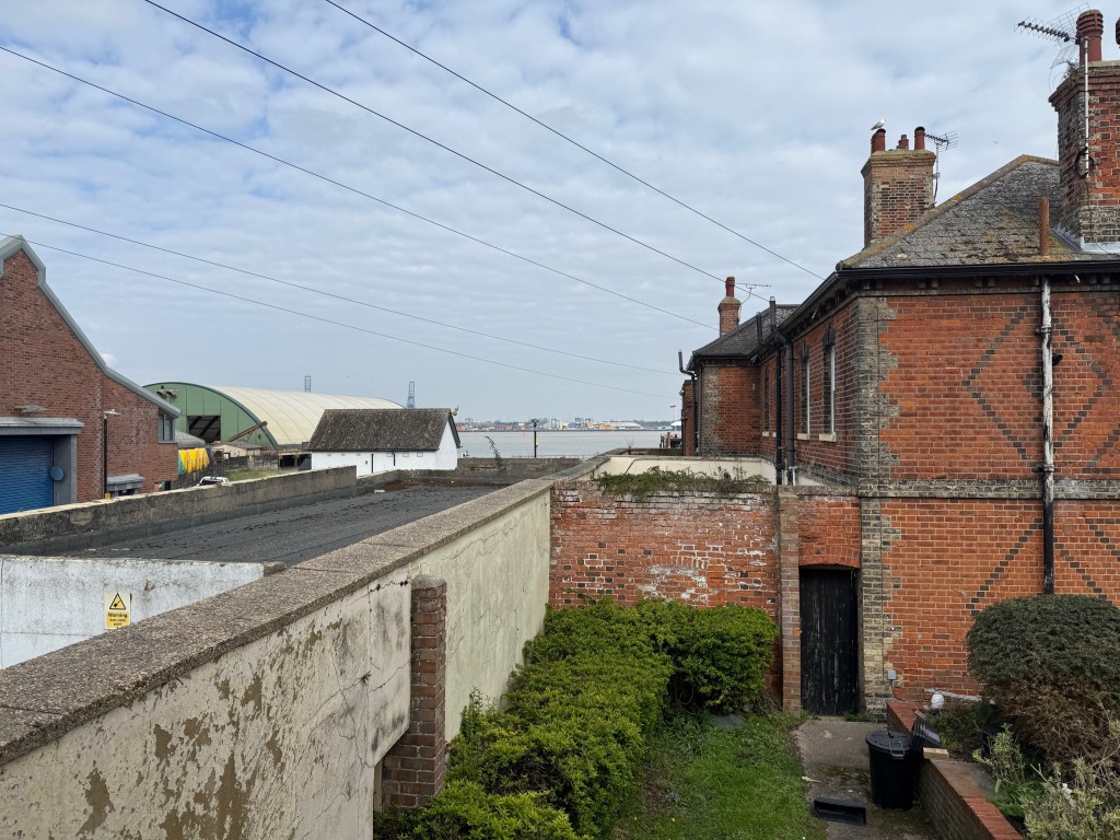 Lot: 110 - THREE-BEDROOM END-TERRACE COTTAGE FOR IMPROVEMENT - View from the window of bedroom 1 toward the sea and port